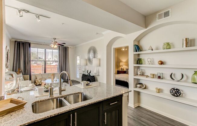 staged kitchen with granite-style countertops and built-in bookshelves