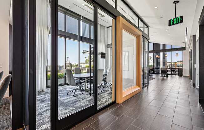 A modern office space with a view of the outdoors through large windows.