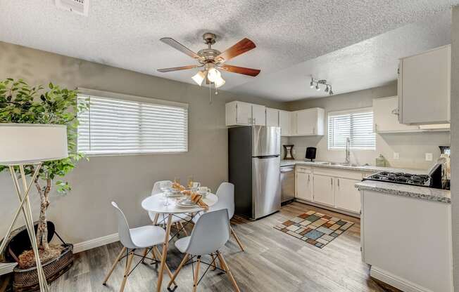 an open kitchen and dining room with a white table and chairs at Desert Bay Apartments, Laughlin, NV, 89029