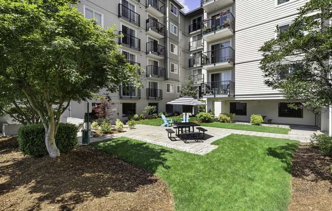 Resident Outdoor Lounge Space with a patio and picnic table with umbrella at King Arthurs Court, Seattle, Washington
