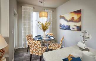 a dining room with a table and chairs and a painting on the wall