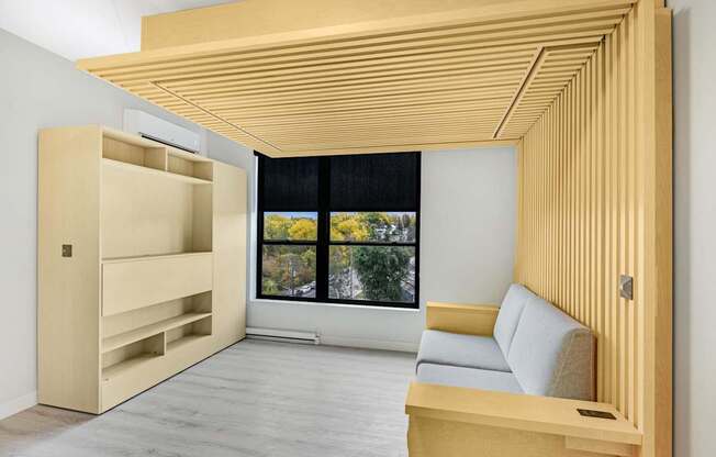 A room with a window and a couch.