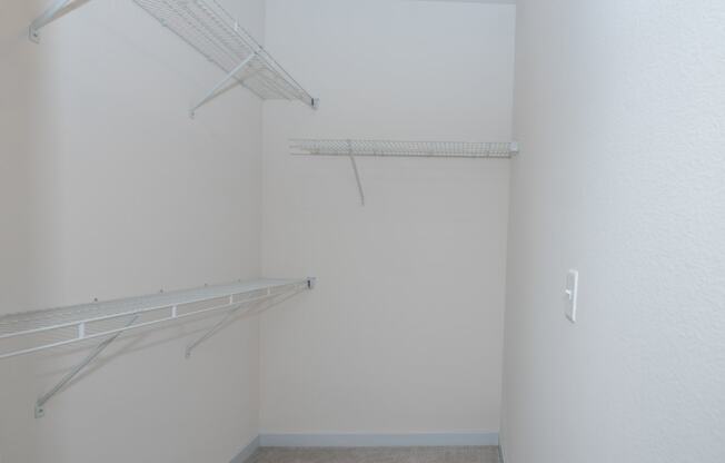 a room with a hanging rack on the wall and a closet at The Crossings at Windsong, Prescott Valley, AZ