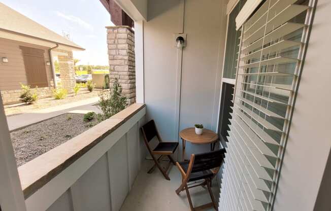 a balcony with two chairs and a small table