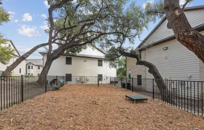 our yard is fenced in with trees and a picnic table