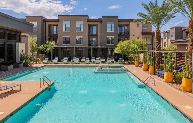A large swimming pool in front of apartment buildings.
