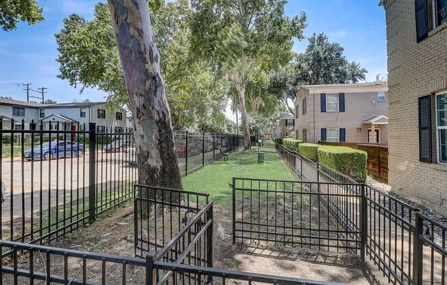 our apartments have a fenced in yard with grass and trees
