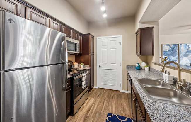 A kitchen with a stainless steel refrigerator and a sink.