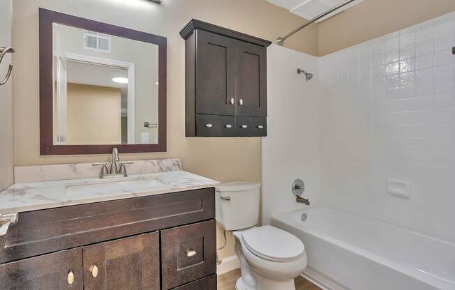 A bathroom with a white toilet and a white bathtub.