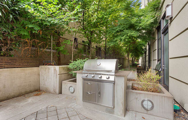 a backyard with a stainless steel grill on the side of a house