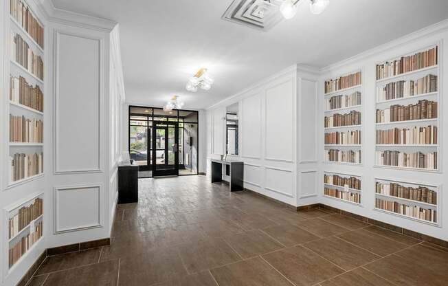 A room with white bookshelves filled with books.