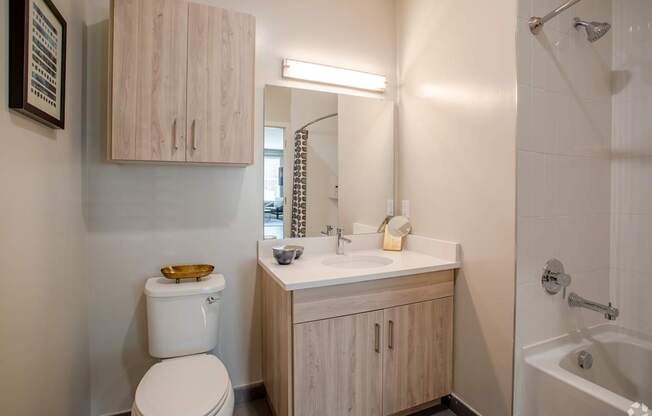 A white toilet sits next to a sink in a small bathroom.