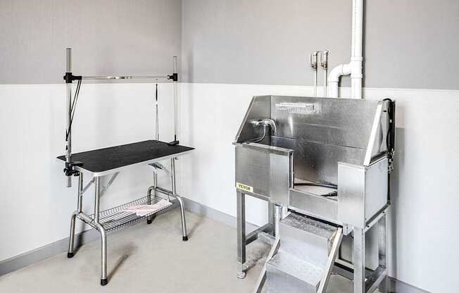 A stainless steel table and sink in a clean, white room.