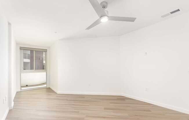 A room with a ceiling fan and a window. at Elements Apartments*, California