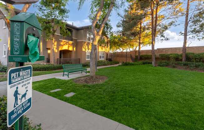 A sign in front of a building that says "Pet Waste Transmitters Leash Off After 15".