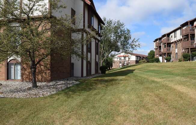 a large building with a grass lawn and trees at Seville Apartments, Michigan