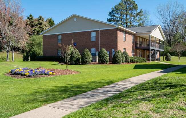 A brick house with a flower bed in front.
