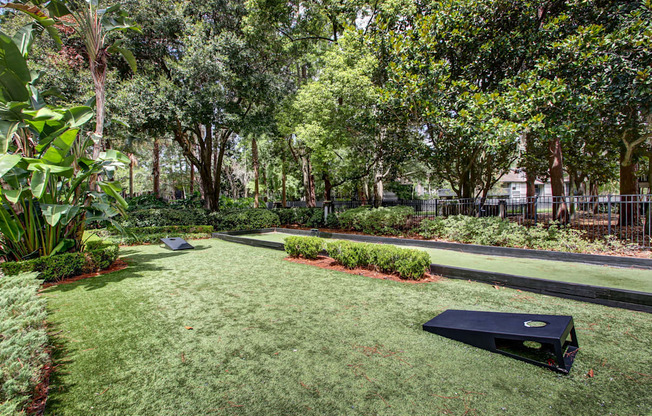 A black object is on the grass in a well kept garden.