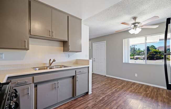 an empty kitchen with stainless steel appliances and a ceiling fan