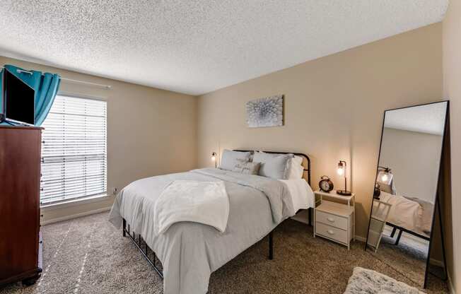 a bedroom with a bed and a dresser and a mirror