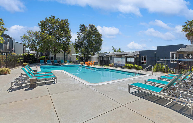 Community Swimming Pool with Pool Furniture at Colonnade at Fletcher Hills Apartments in El Cajon, CA.