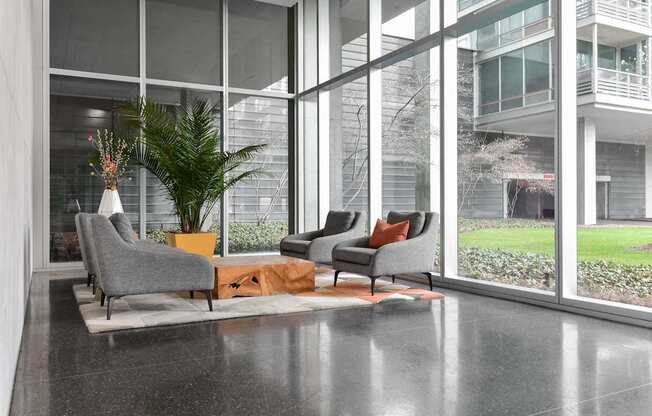 A modern living room with grey chairs and a large window.