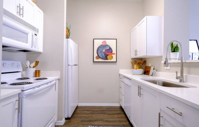 luxury kitchen with modern white cabinetry and gleaming countertops at Roosevelt Square apartments