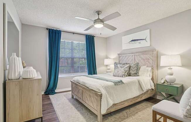 A bedroom with a bed, nightstand, and a ceiling fan.