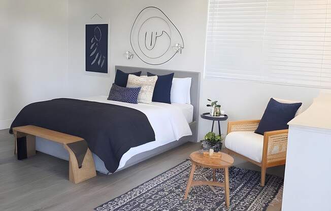 A bedroom with a bed, a bench, and a rug.