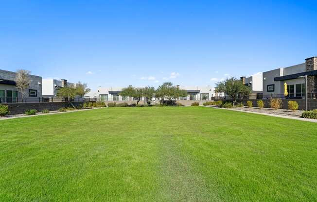 a large green lawn in front of some apartments