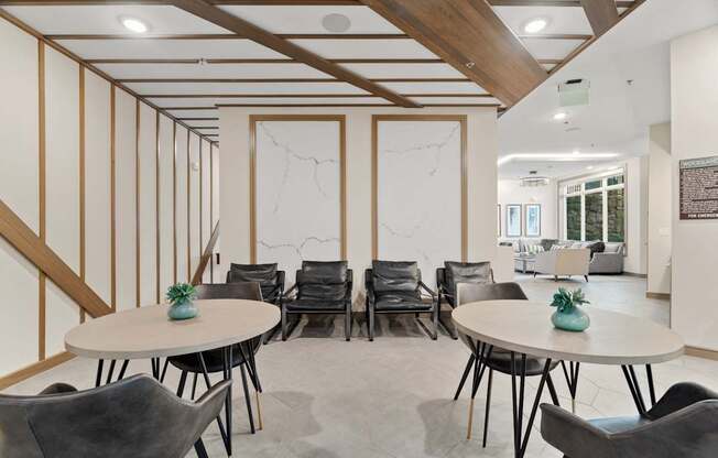 A room with a white table and black chairs.