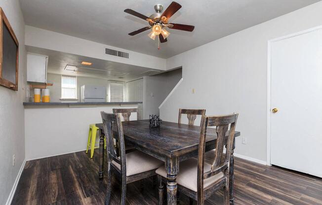 a dining room with a table and chairs and a ceiling fan