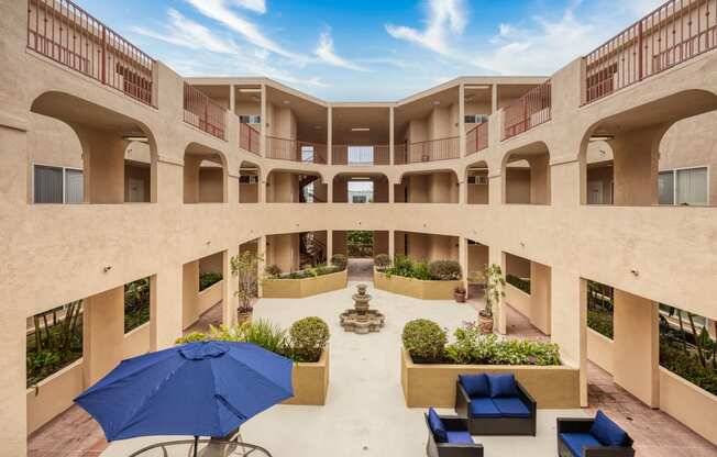 a courtyard with seating and a fountain in the middle of a building