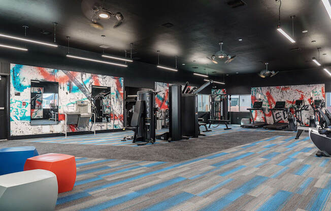 a fitness room with a mural of graffiti on the wall and exercise equipment