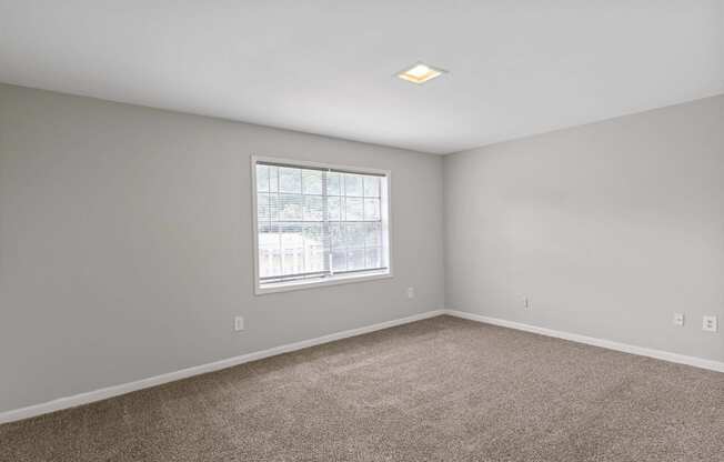 an empty room with carpet and a window