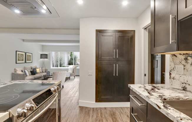 Kitchen with Stainless steel electric range, pantry, wood style floors, dark brown kitchen cabinets