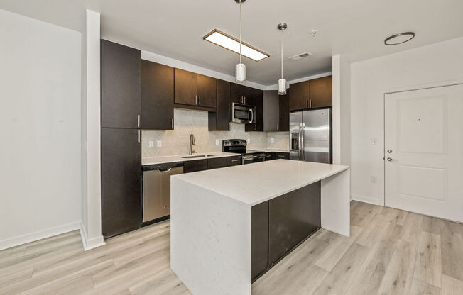 a kitchen with a large island and stainless steel appliances