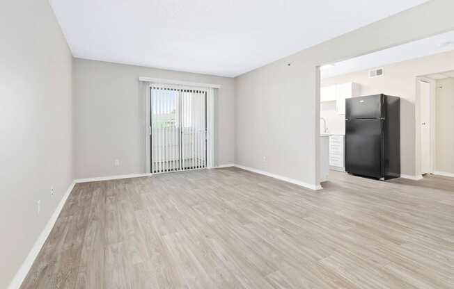 a bedroom with a large window and hardwood flooring