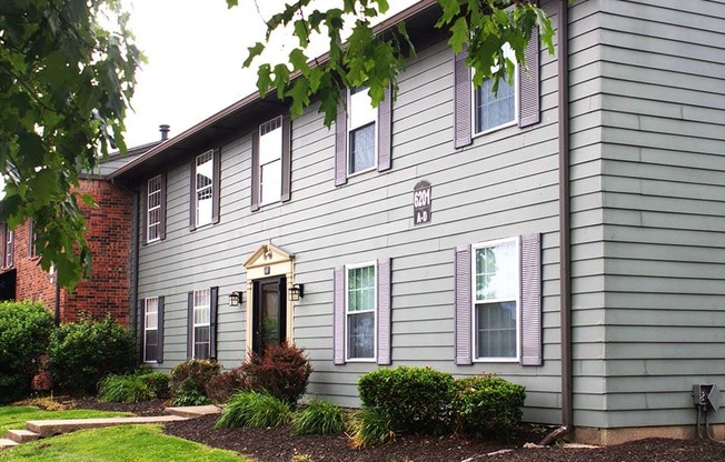 a gray house with a red brick chimney