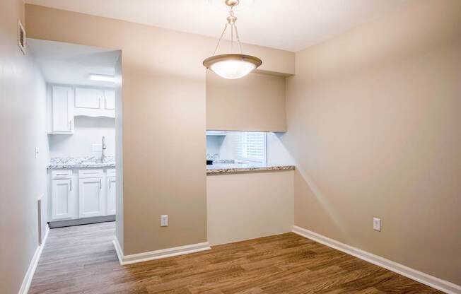 A room with a window and a wooden floor.
