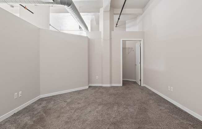 an empty room with carpet and a door to a closet