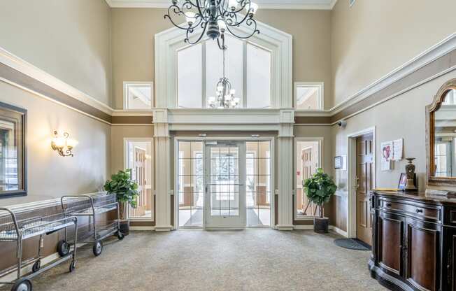 a large hallway with a chandelier and a glass door