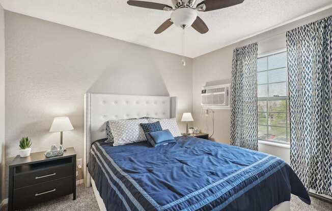 A bedroom with a large bed and a ceiling fan.