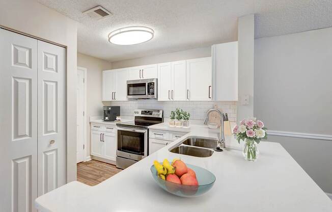 A kitchen with a bowl of fruit on the counter.