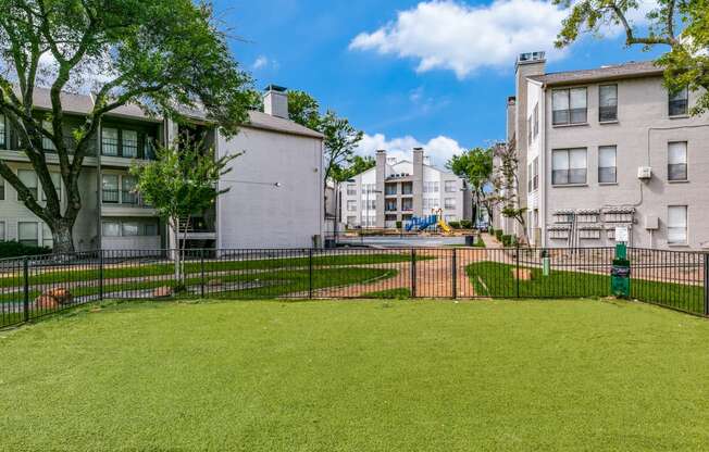 the yard is fenced in with a green lawn and a pool