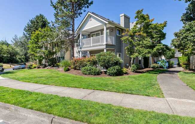 A house with a well-maintained lawn and a clear sky.