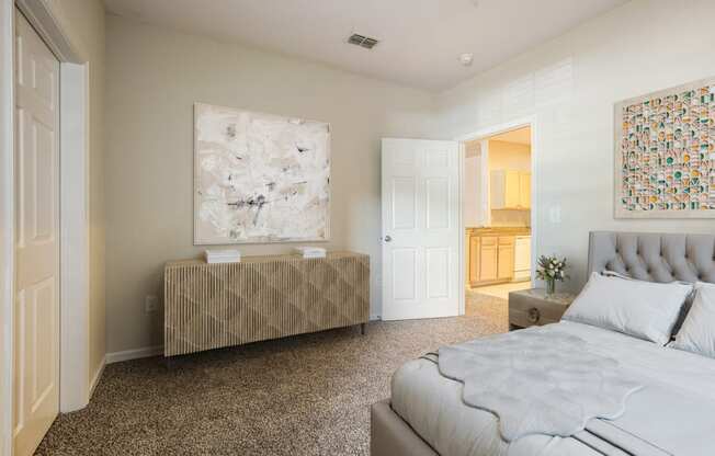 a bedroom with a bed and a dresser and a painting on the wall