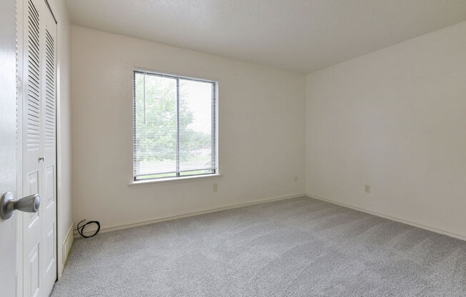 Spacious Bedroom with Large Window at Old Monterey Apartments in Springfield, MO
