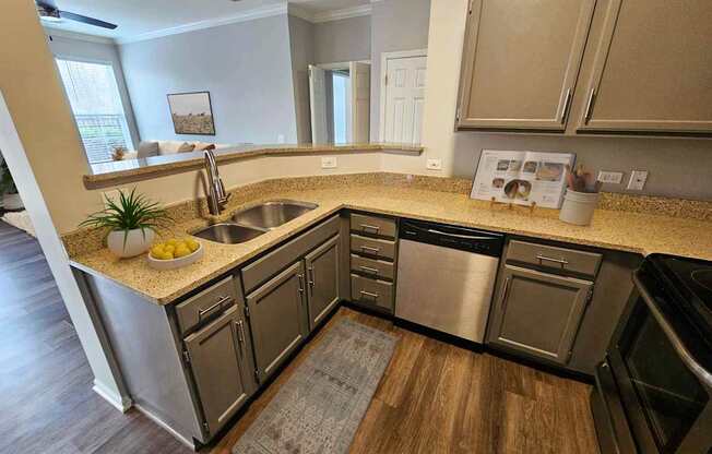 A kitchen with a sink, stove, and oven.