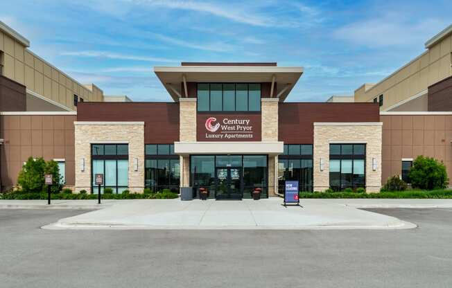 a large building with a sign on the front of it  at Century West Pryor, Lee's Summit, MO